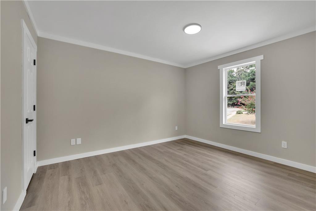 4913 Windsor Downs Drive Decatur, GA 30035 - Photo 14 of 26 a view of an empty room with wooden floor and a window