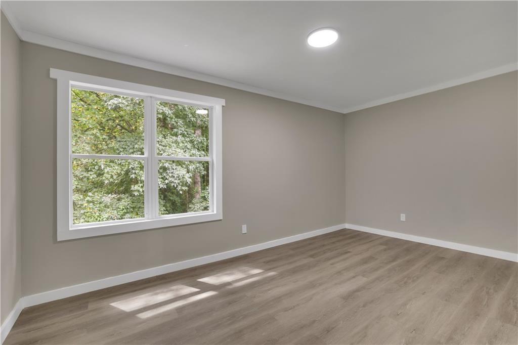 4913 Windsor Downs Drive Decatur, GA 30035 - Photo 15 of 26 a view of an empty room with wooden floor and a window
