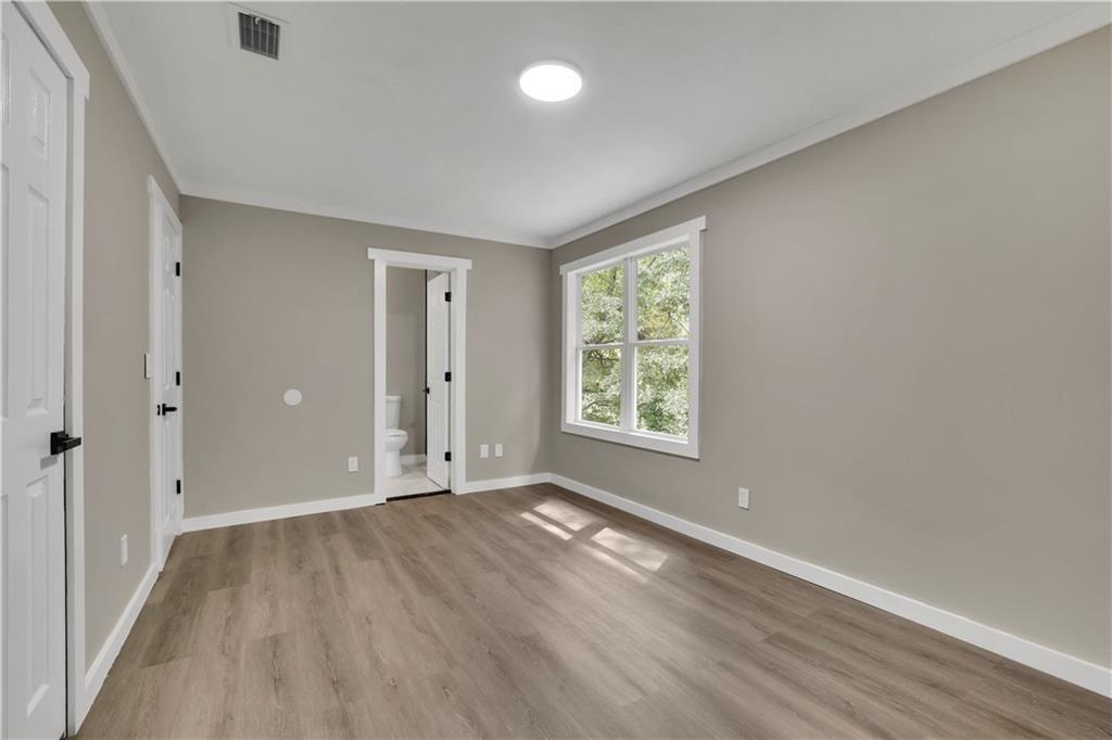 4913 Windsor Downs Drive Decatur, GA 30035 - Photo 16 of 26 an empty room with wooden floor and windows