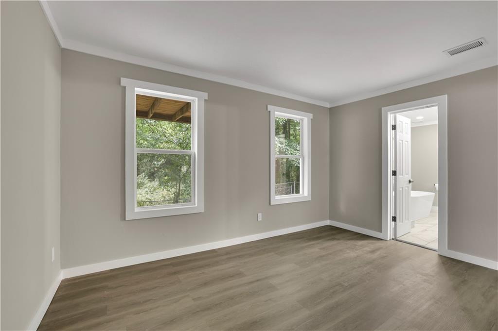 4913 Windsor Downs Drive Decatur, GA 30035 - Photo 17 of 26 a view of an empty room with wooden floor and a window