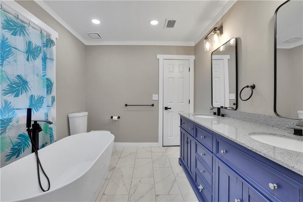 4913 Windsor Downs Drive Decatur, GA 30035 - Photo 18 of 26 a bathroom with a double vanity sink and mirror with toilet