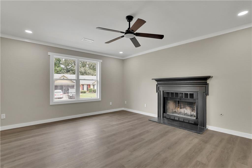 4913 Windsor Downs Drive Decatur, GA 30035 - Photo 4 of 26 a view of an empty room with wooden floor fireplace and a window