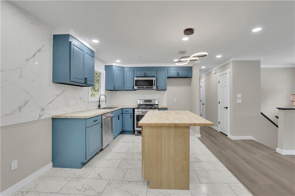 4913 Windsor Downs Drive Decatur, GA 30035 - Photo 6 of 26 a kitchen with a sink a counter top space stainless steel appliances and cabinets
