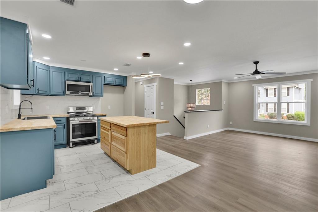 4913 Windsor Downs Drive Decatur, GA 30035 - Photo 7 of 26 a large kitchen with stainless steel appliances granite countertop a stove a sink and a microwave
