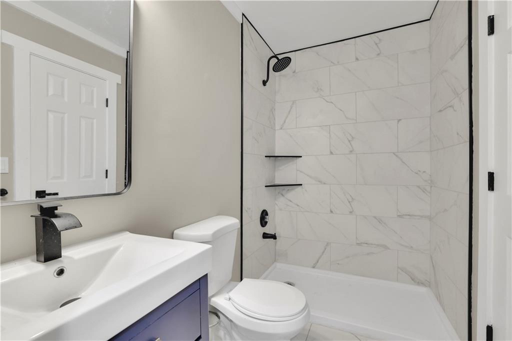 4913 Windsor Downs Drive Decatur, GA 30035 - Photo 9 of 26 a bathroom with a sink a toilet and shower