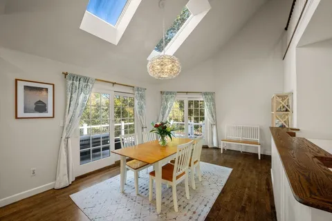 a dining room with wooden floor and a chandelier