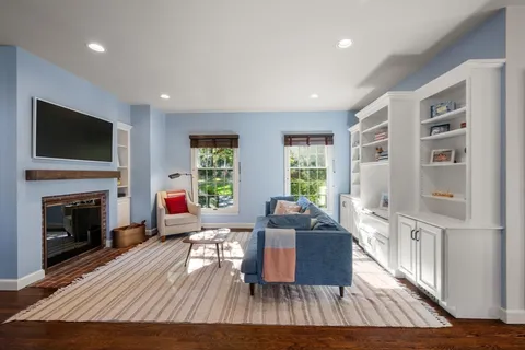 a living room with furniture a flat screen tv and a fireplace