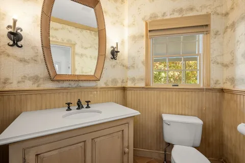 a bathroom with a toilet sink and mirror