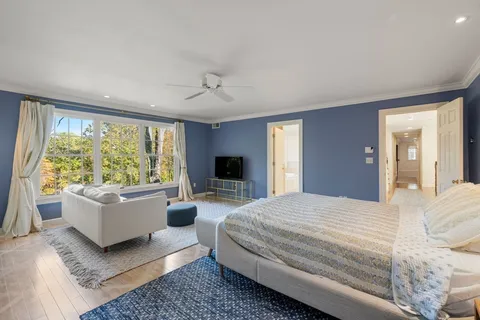 a bedroom with a large bed couch and a window