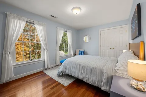 a bedroom with a bed and wooden floor