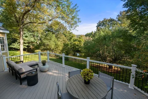 a view of a balcony with wooden floor and outdoor seating