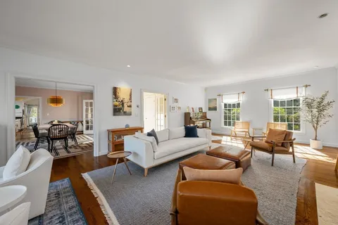 a living room with furniture wooden floor and a large window