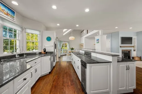 a kitchen with granite countertop a sink stove and cabinets