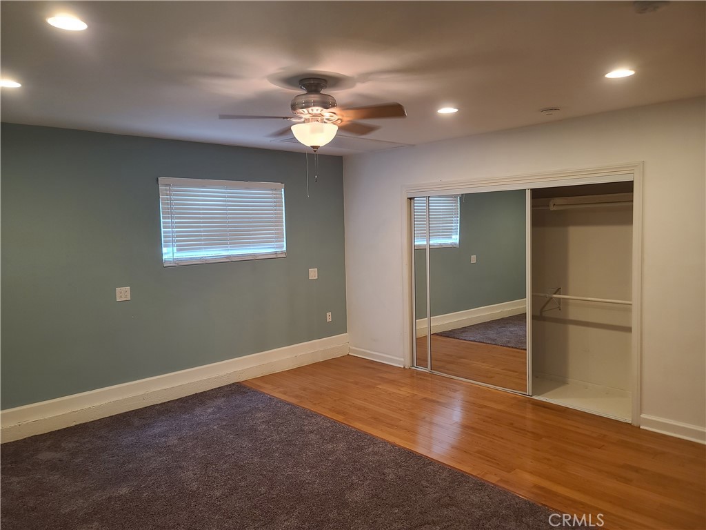 Undisclosed Address Simi Valley, CA 93063 - Photo 13 of 17 an empty room with wooden floor chandelier fan and windows