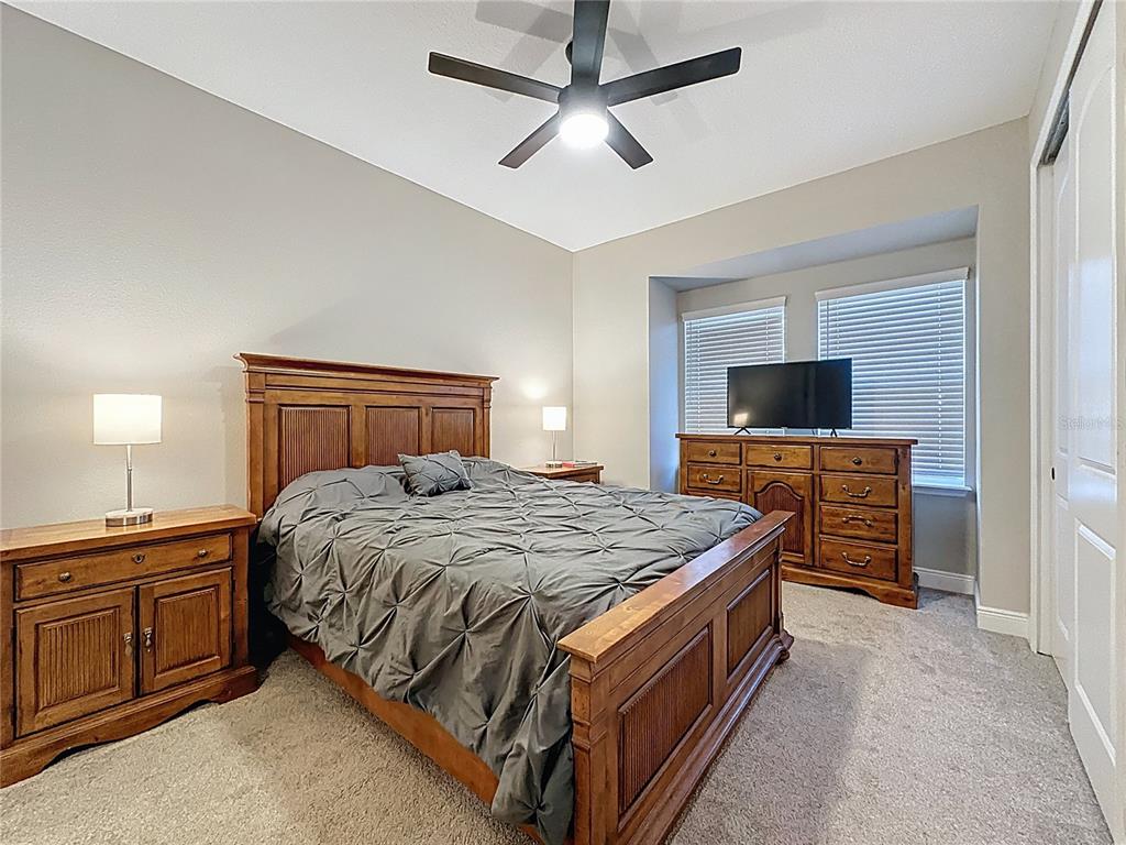 115 Silver Maple Road Groveland, FL 34736 - Photo 21 of 79 a bedroom with a bed and a flat screen tv