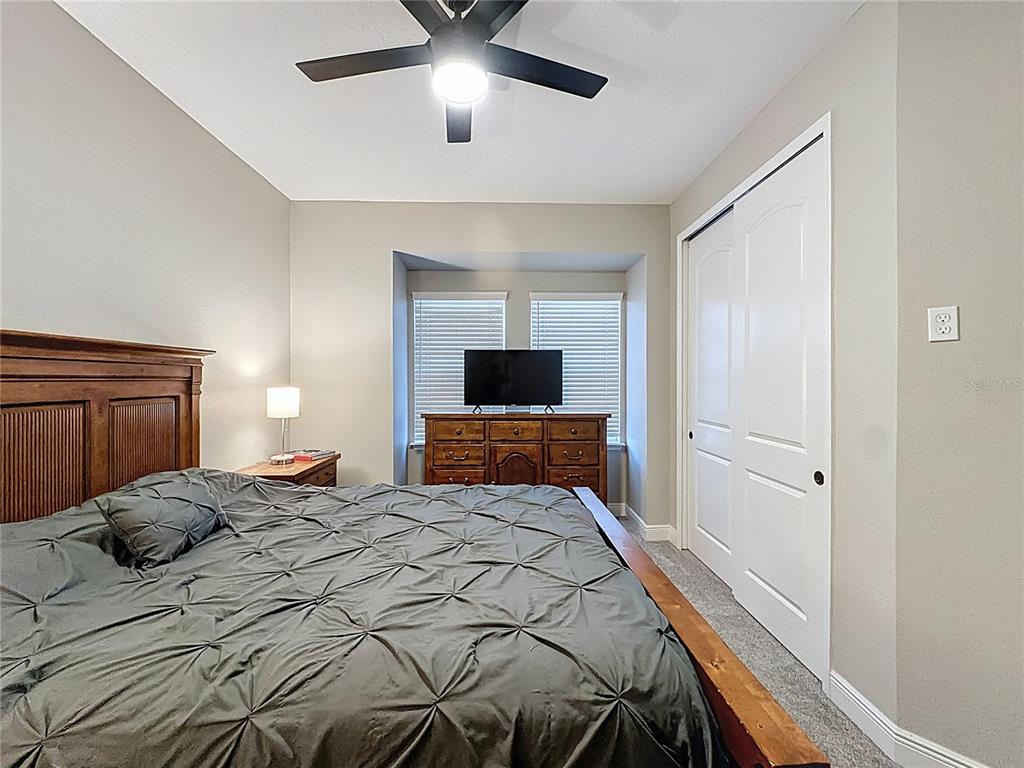 115 Silver Maple Road Groveland, FL 34736 - Photo 22 of 79 a bedroom with a bed and a flat screen tv