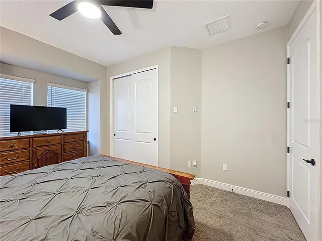 a bedroom with a bed window and a chandelier