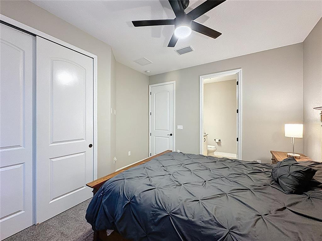 115 Silver Maple Road Groveland, FL 34736 - Photo 24 of 79 a bedroom with a bed and a chandelier