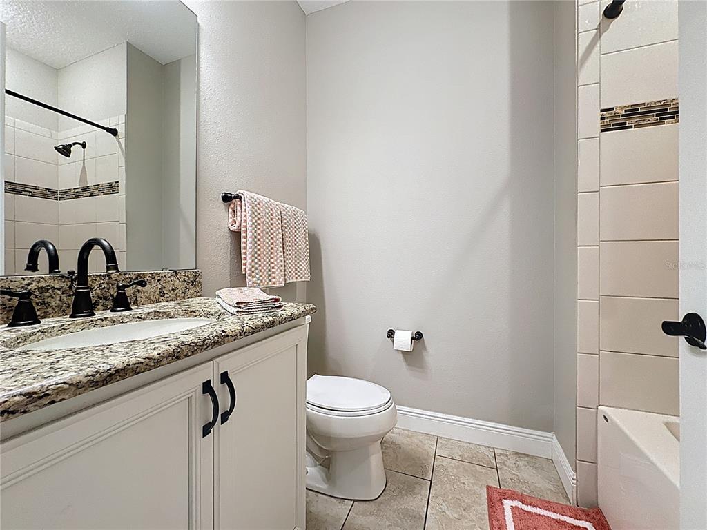 115 Silver Maple Road Groveland, FL 34736 - Photo 25 of 79 a bathroom with a granite countertop sink toilet and shower