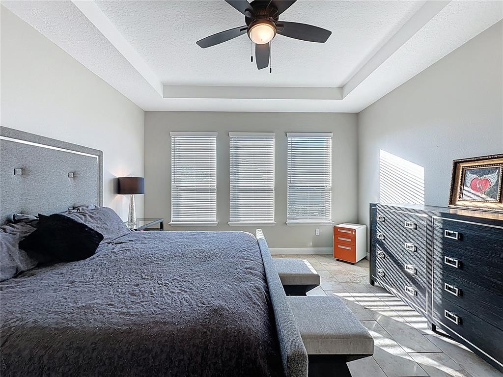 115 Silver Maple Road Groveland, FL 34736 - Photo 30 of 79 a bedroom with a bed window and a chandelier