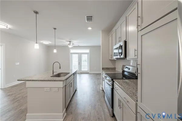a kitchen with stainless steel appliances granite countertop a sink stove and refrigerator
