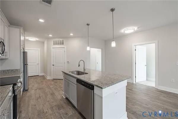 a kitchen with a sink cabinets and wooden floor
