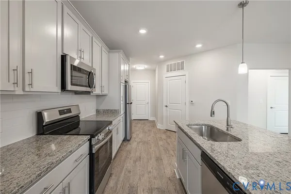 a kitchen with a sink refrigerator and a counter top space