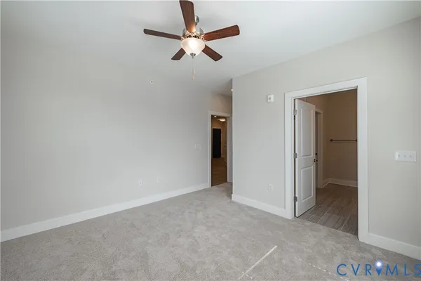 an empty room with closet and fan