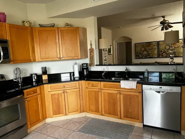 a kitchen with stainless steel appliances granite countertop a refrigerator a sink dishwasher and a stove