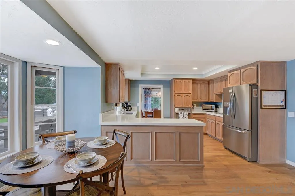 133 Hummingbird Hill Encinitas, CA 92024 - Photo 7 of 25 a kitchen with refrigerator cabinets dining table and chairs