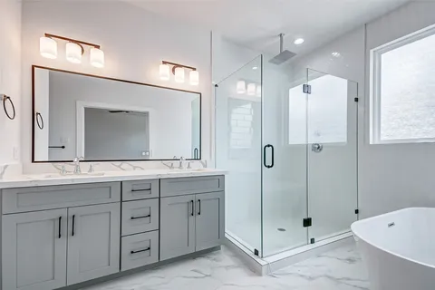 a bathroom with a double vanity sink mirror and shower