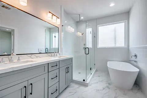 a spacious bathroom with a double vanity sink mirror and bathtub
