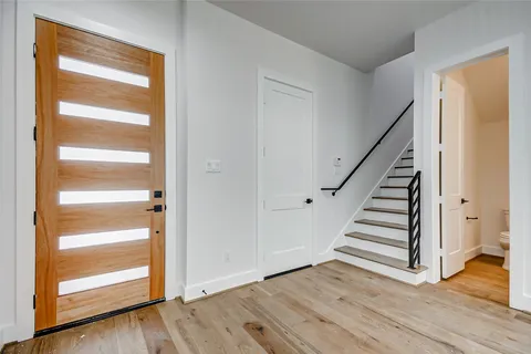a view of an empty room with wooden floor and entryway