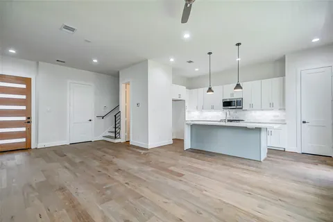 a view of kitchen with stainless steel appliances granite countertop cabinets and wooden floor