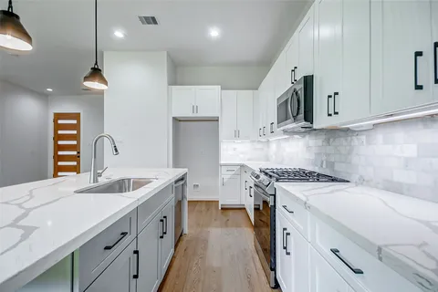 a kitchen with a sink a stove and cabinets