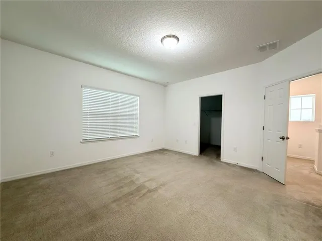 an empty room with windows and closet