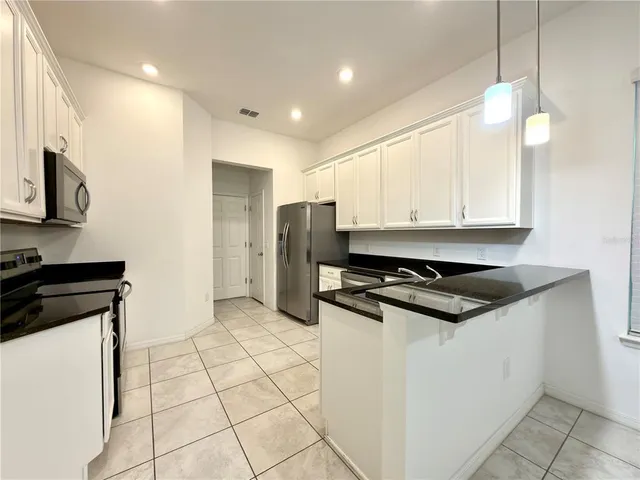 a kitchen with stainless steel appliances granite countertop a stove and a refrigerator