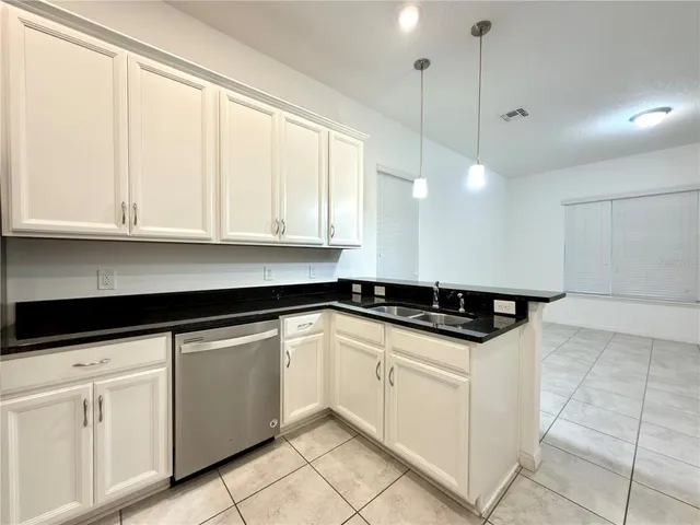 a kitchen with granite countertop white cabinets and white appliances