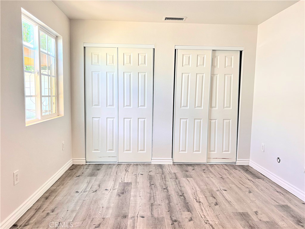 20009 Arminta Street Winnetka, CA 91306 - Photo 13 of 29 an empty room with wooden floor and windows