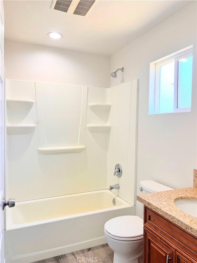 20009 Arminta Street Winnetka, CA 91306 - Photo 15 of 29 a bathroom with a granite countertop bathtub shower sink vanity and toilet