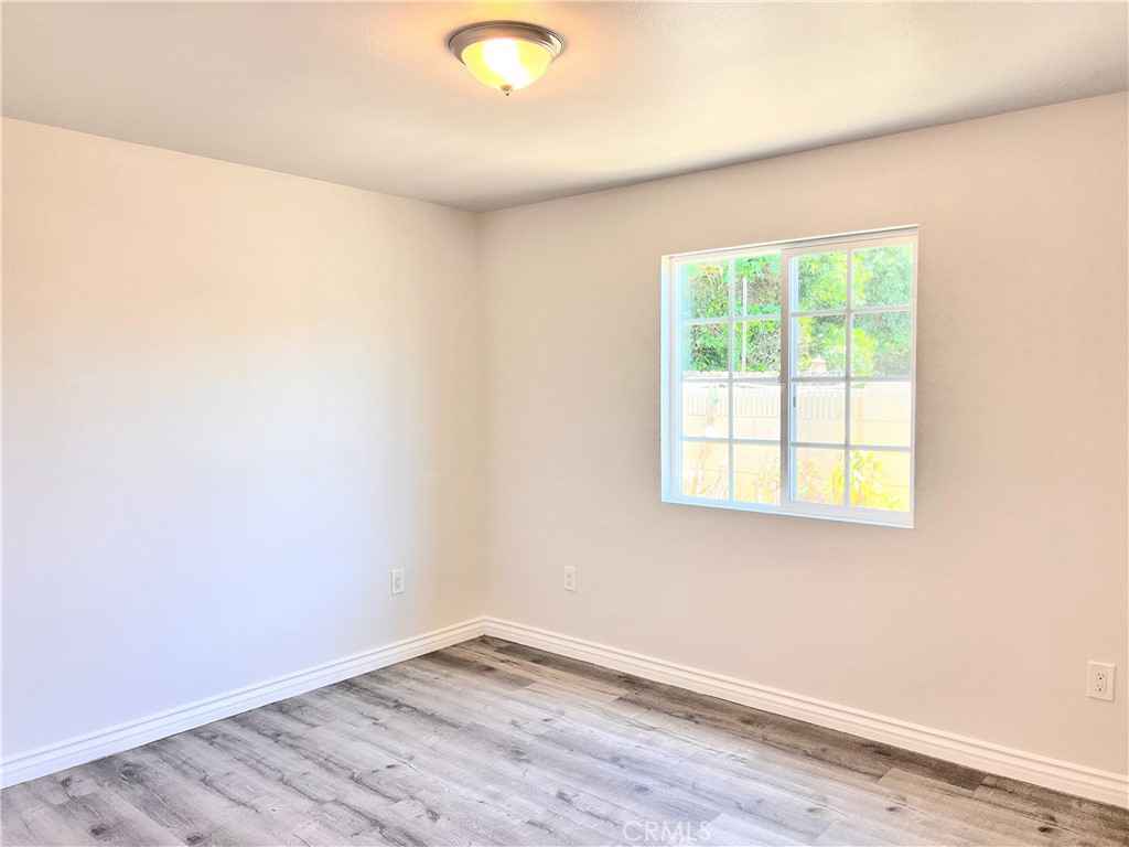 20009 Arminta Street Winnetka, CA 91306 - Photo 18 of 29 an empty room with wooden floor and windows