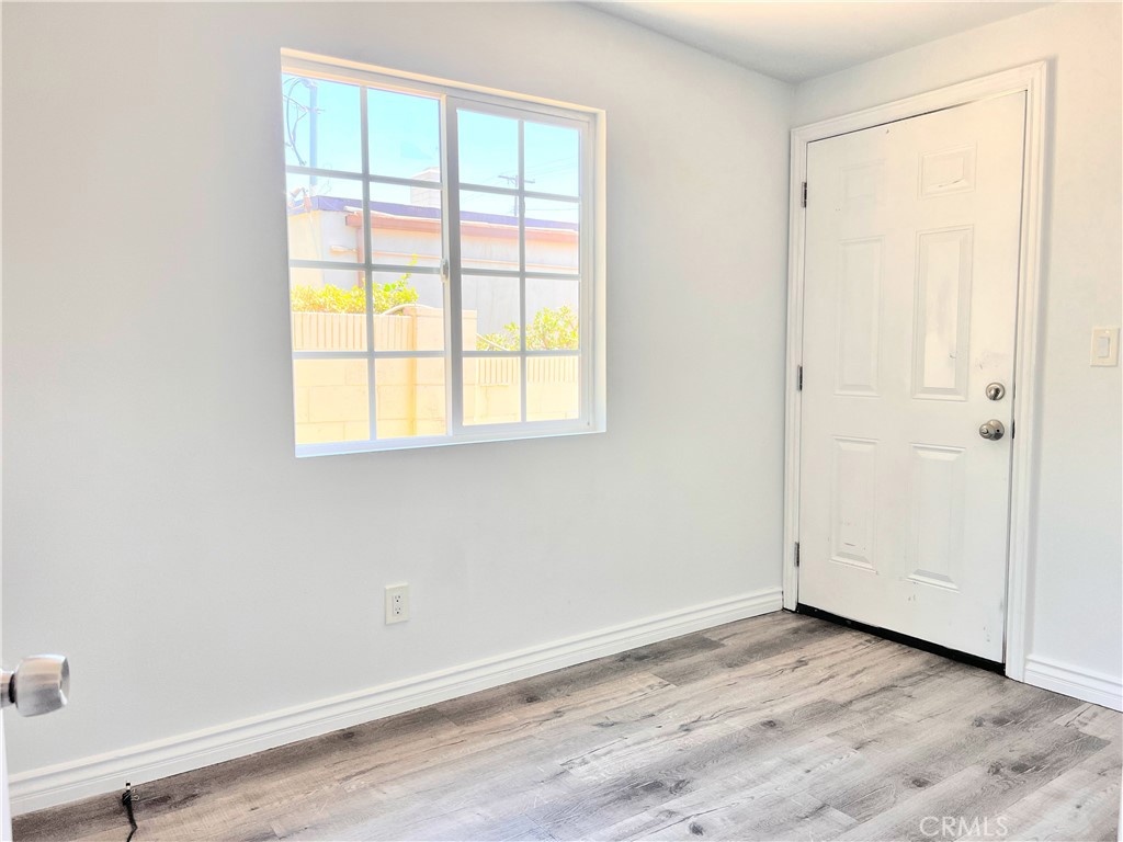 20009 Arminta Street Winnetka, CA 91306 - Photo 24 of 29 an empty room with wooden floor and windows