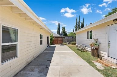 20009 Arminta Street Winnetka, CA 91306 - Photo 27 of 29 a view of a patio with dining table and chairs with wooden floor and fence