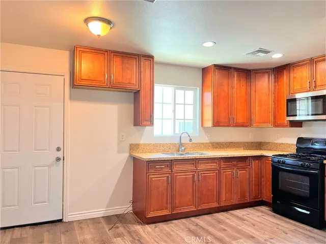 a kitchen with granite countertop cabinets stainless steel appliances and a window