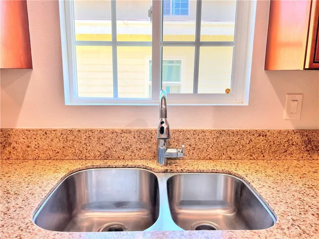 a kitchen with sink a microwave and cabinets