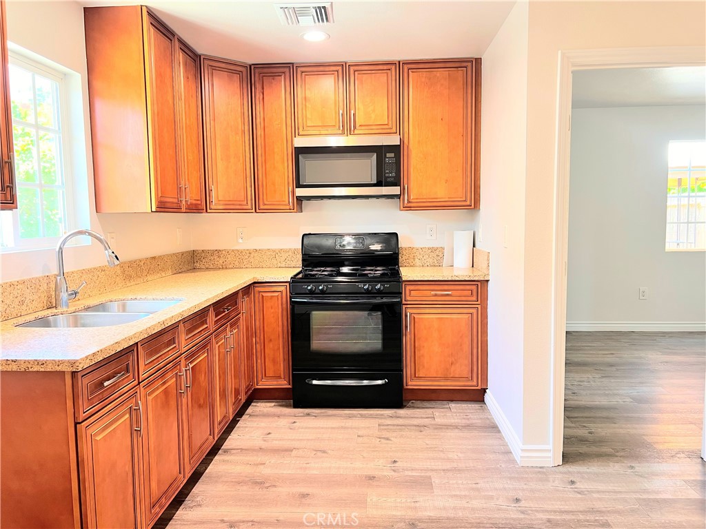 20009 Arminta Street Winnetka, CA 91306 - Photo 10 of 29 a kitchen with sink a microwave and cabinets