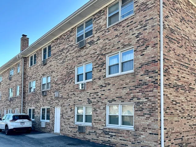 a brick building with a door and a yard