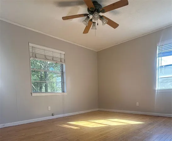 an empty room with a window and a fan