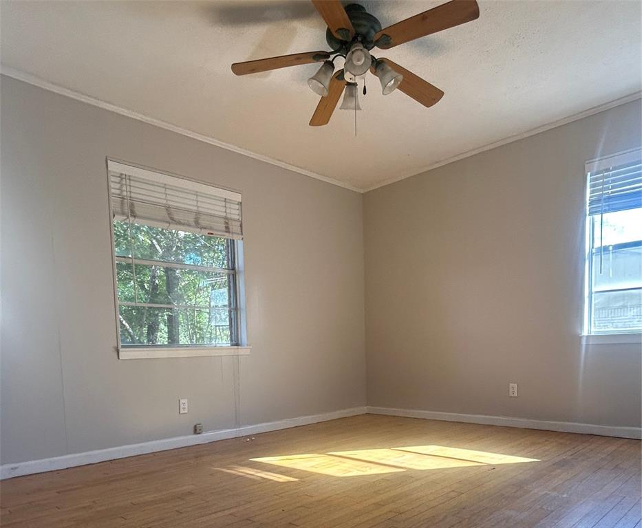 2609 Washington Street Commerce, TX 75428 - Photo 7 of 20 an empty room with a window and a fan