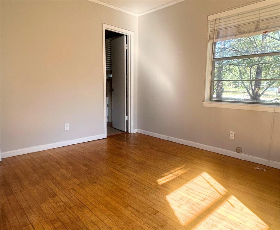 2609 Washington Street Commerce, TX 75428 - Photo 8 of 20 an empty room with wooden floor and windows